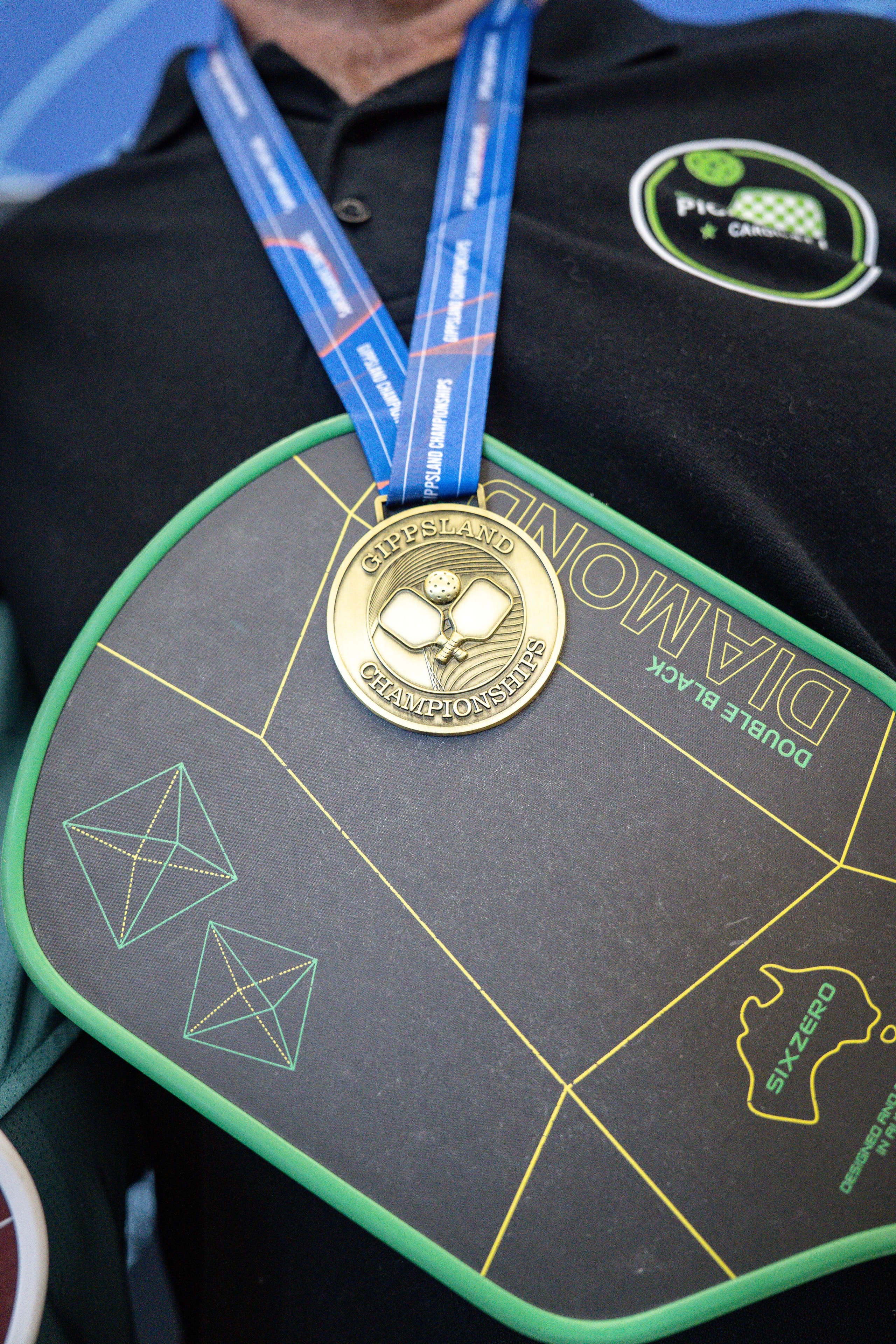 Gippsland Championships gold medal resting on a pickleball paddle